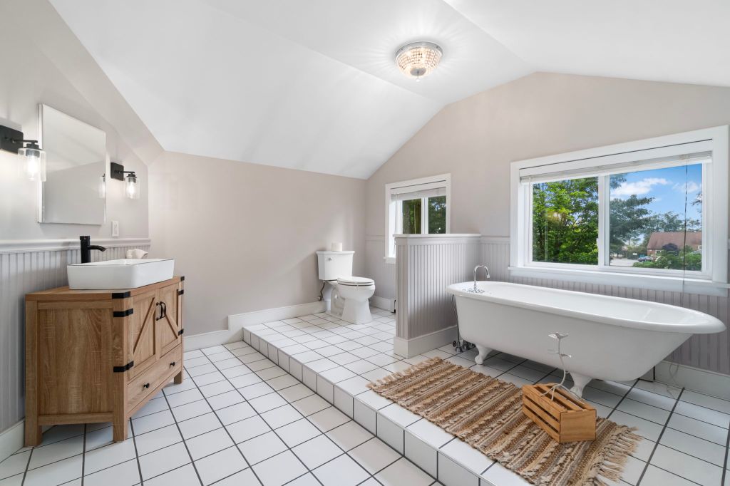 A spacious modern scrubbed bathroom with an all-white interior. The room is bright white and pale beige. There is a freest...